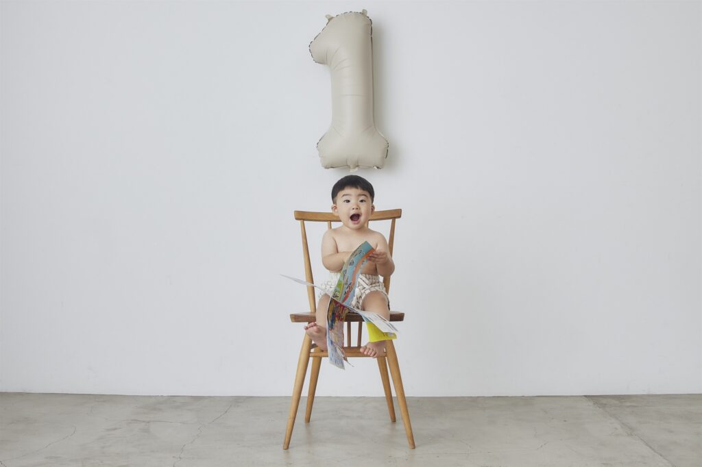 1歳のバルーンと椅子に座る男の子のバースデーフォト